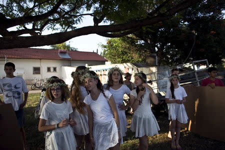 Girls wearing white dresses and flower wreaths prepare to perform at the annual harvest festival in Kibbutz Degania Alef on the shores of the Sea of Galilee, northern Israel May 23, 2015. REUTERS/Ronen Zvulun