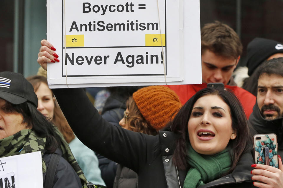 FILE - Nationally known far-right activist Laura Loomer holds up a sign across the street from a rally organized by Women's March NYC, Jan. 19, 2019, after she barged onto the stage interrupting Women's March NYC director Agunda Okeyo who was speaking during a rally in New York. Loomer, who's been banned by several social media platforms because of anti-Muslim and other remarks, is challenging incumbent Republican Dan Webster, who has served central Florida districts since 2011. (AP Photo/Kathy Willens, File)