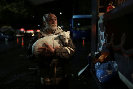 Bob Talk, who was in the process of moving out of the RV he rented in Paradise when the Camp Fire hit, holds his dog Princeton after being served Thanksgiving dinner in Chico, California, U.S. November 22, 2018. REUTERS/Elijah Nouvelage