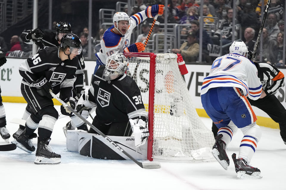 Edmonton Oilers center Connor McDavid, right, celebrates his goal with left wing Zach Hyman, second from right, as Los Angeles Kings goaltender Cam Talbot, center, kneels in goal while defenseman Vladislav Gavrikov, left, and center Blake Lizotte watch during Game 3 of an NHL hockey Stanley Cup first-round playoff series Friday, April 26, 2024, in Los Angeles. (AP Photo/Mark J. Terrill)