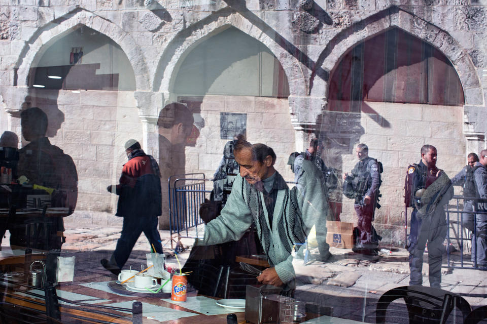 A waiter cleans a table in a restaurant in Jerusalem Old City, Israel