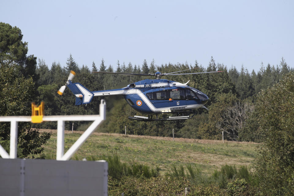 A gendarme helicopter takes off near the site of a jet crash near Pluvigner, western France, Thursday, Sept.19, 2019. A Belgian F-16 fighter jet crashed in western France, damaging a house, setting a field ablaze and leaving a pilot suspended for two hours from a high-voltage electricity line after his parachute got caught, according to French authorities. (AP Photo/David Vincent)