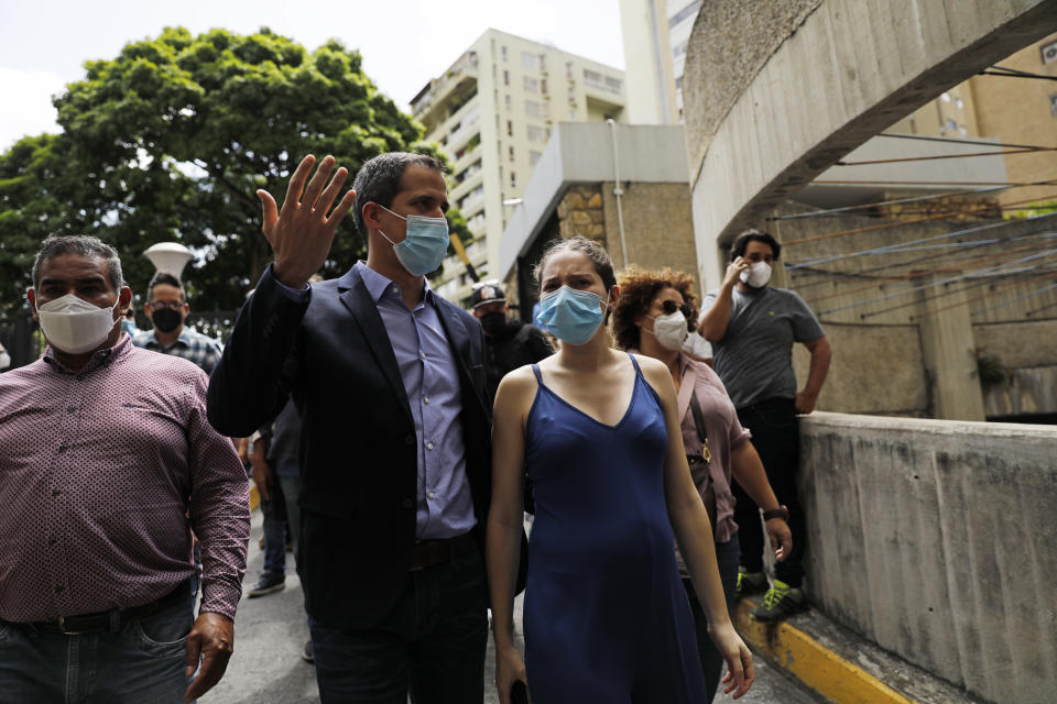Opposition leader Juan Guaido and his wife Fabiana Rosales walk at their residential building after holding an impromptu press conference in Caracas, Venezuela, Monday, July 12, 2021. Guaido said security forces threatened his driver when he and his driver arrived home Monday. (AP Photo/Ariana Cubillos)