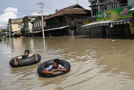 Men wade along a flooded street at Kalay township at Sagaing division, August 2, 2015. REUTERS/Soe Zeya Tun