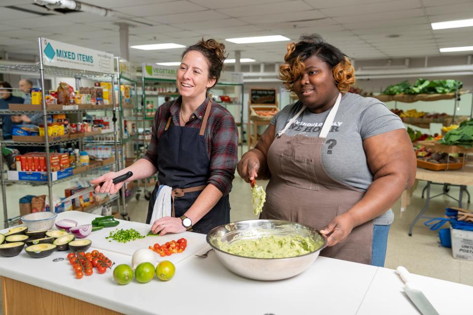 Food center director Caitlin Cullen, left, and volunteer Tiffany Madlock, right, prepare guacamole during a food demonstration at Kinship Community Food Center in Milwaukee's Riverwest neighborhood.