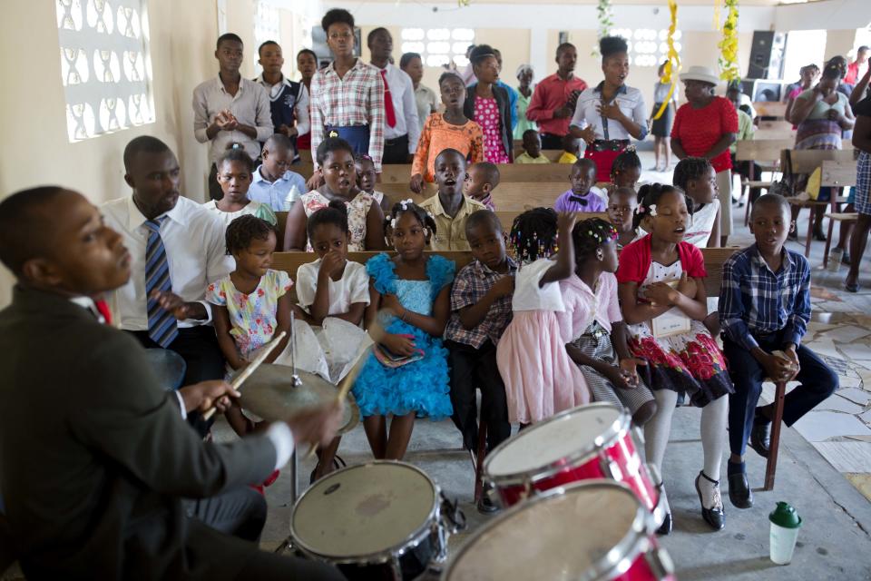 Franchina 11, first row second from right, attends Mass with her foster family at a Baptist church in Port-au-Prince, Haiti on Sunday, July 1, 2018. (AP Photo/Dieu Nalio Chery)