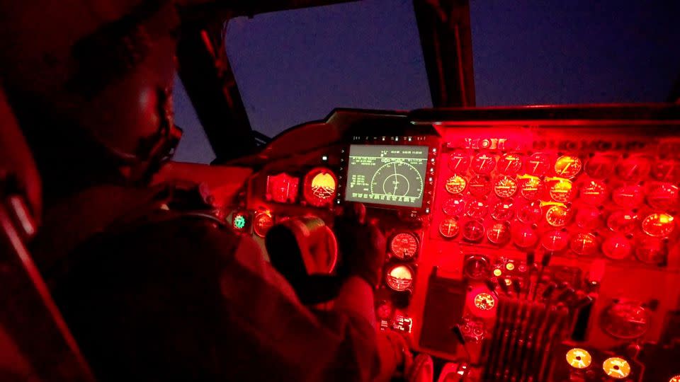 Capt. Sabin “Jett” Park pilots the B-52 at night, using red cockpit lighting to protect his vision in the dark. The main display is one of the few modern additions to the cockpit. - Oren Liebermann/CNN