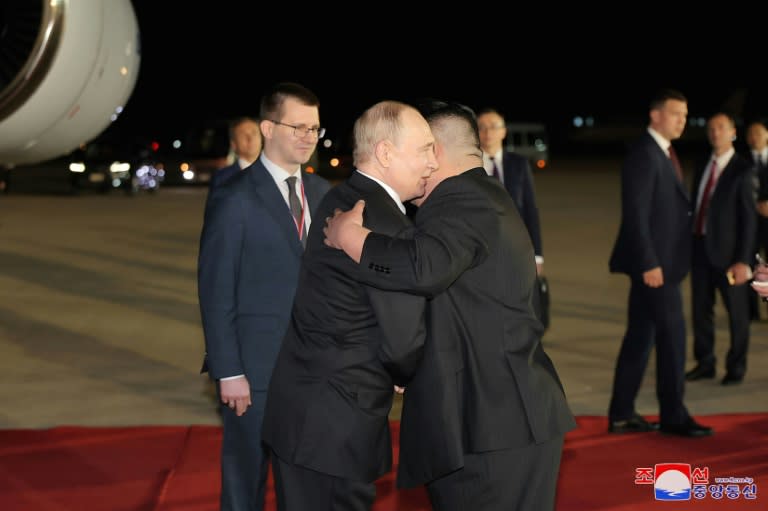 Russia's Vladimir Putin (L) and North Korea's Kim Jong Un embraced on the runway in Pyongyang early Wednesday (STR)