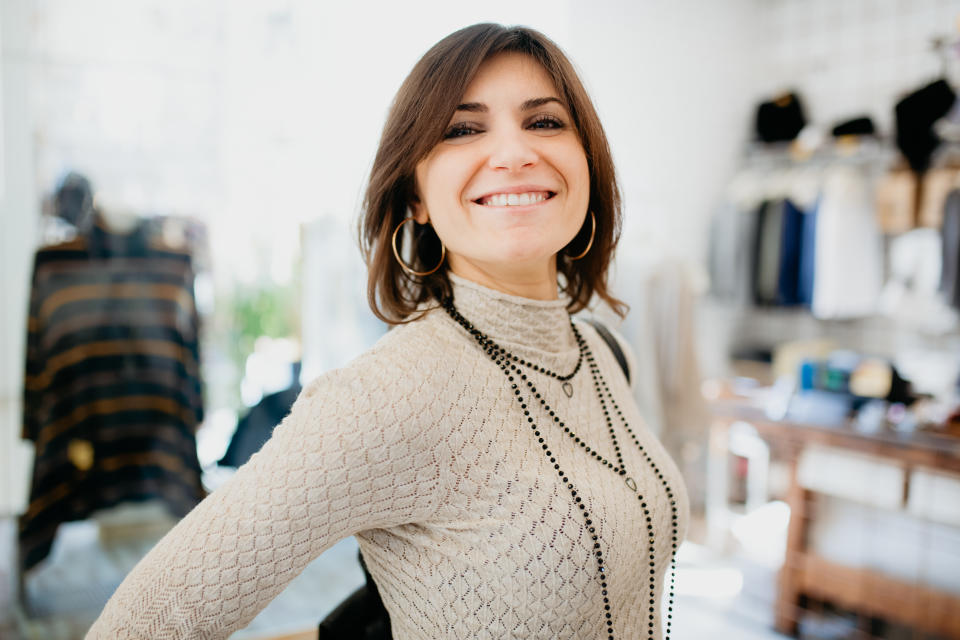 Woman showing off necklace in fashion boutique