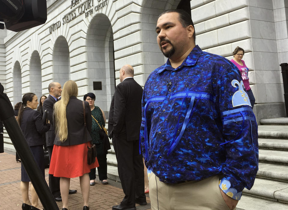 Tehassi Hill, tribal chairman of the Oneida Nation, stands outside a federal appeals court Wednesday, March 13, 2019 in New Orleans, following arguments on the constitutionality of a law giving Native American families preference in adoption of Native American children. A Texas-based federal judge ruled the 1978 law unconstitutional last year. Hill is among leaders of various Native American tribes hoping the 5th U.S. Circuit Court of Appeals will reverse the ruling and uphold the law. (AP Photo/Kevin McGill)