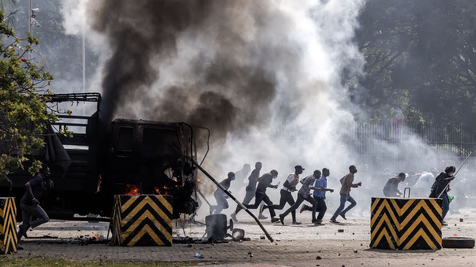 Protesters run to take cover outside the Kenyan Parliament after storming the building. -  Luis Tato/AFP/Getty Images