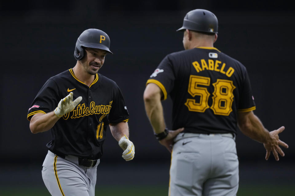 Pittsburgh Pirates' Bryan Reynolds (10) celebrates his two-run home run against the Cincinnati Reds with third base coach Mike Rabelo (58) during the first inning of a baseball game Tuesday, June 25, 2024, in Cincinnati. (AP Photo/Carolyn Kaster)