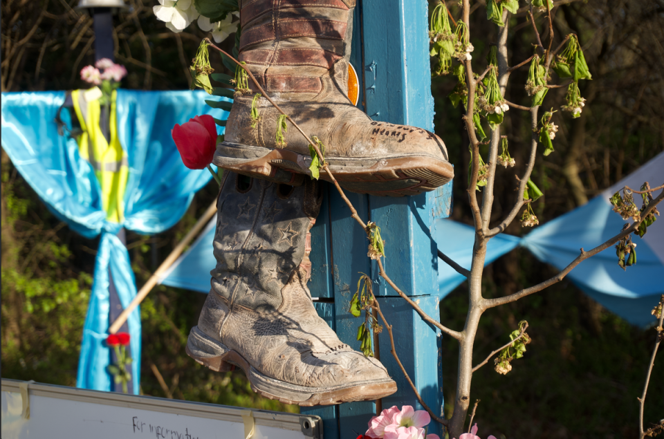 A friend and colleague of the men who died left his construction boots on one of the crosses at the memorial to honor the victims of the Francis Scott Key Bridge Collapse. (Julia Saqui/The Independent)