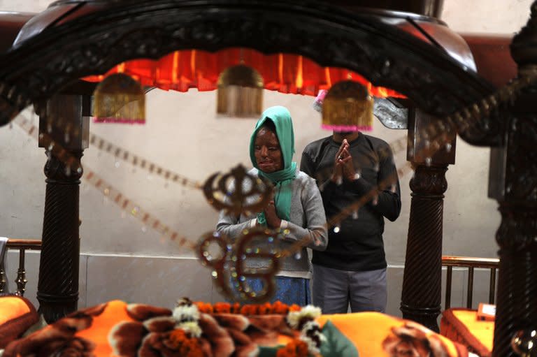 Acid attack survivor Sonali Mukherjee pays her respects as she stands with her father Chandi Das Mukherjee, at a Sikh Temple in New Delhi, on December 6, 2012. When she rejected the advances of three of her fellow students, they responded by melting her face with acid