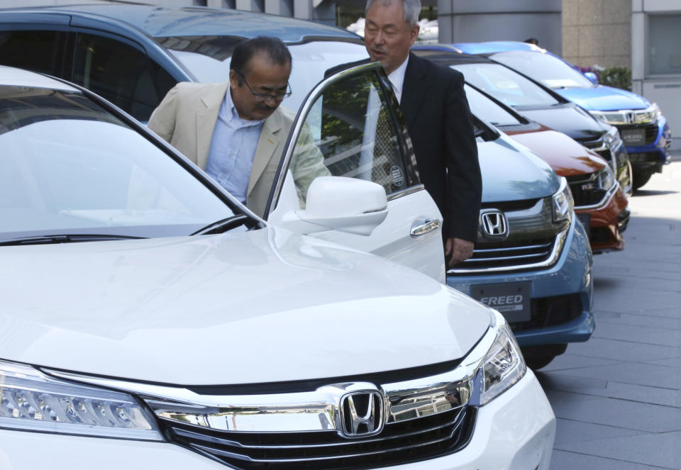 Visitors examine a car displayed at the showroom at the Honda Motor Co. headquarters in Tokyo, Wednesday, May 8, 2019. Honda reported a loss for January-March, despite growing sales, as an unfavorable exchange rate, income tax expenses and other costs hurt results. (AP Photo/Koji Sasahara)