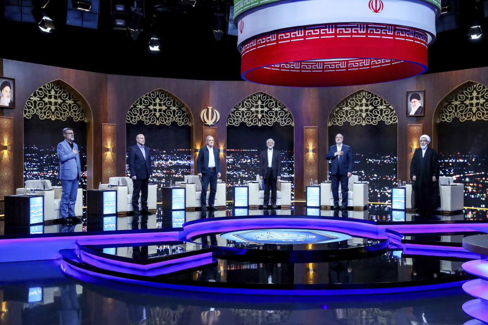 In this picture made available by Iranian state TV IRIB, presidential candidates for June 28 election from left to right; Amirhossein Ghazizadeh Hashemi, Mohammad Bagher Qalibaf, Masoud Pezeshkian, Saeed Jalili, Alireza Zakani, and Mostafa Pourmohammadi listen to the country's national anthem at the start of their debate at a state-run TV studio in Tehran, Iran, Monday, June 17, 2024. (Morteza Fakhri Nezhad/IRIB via AP)