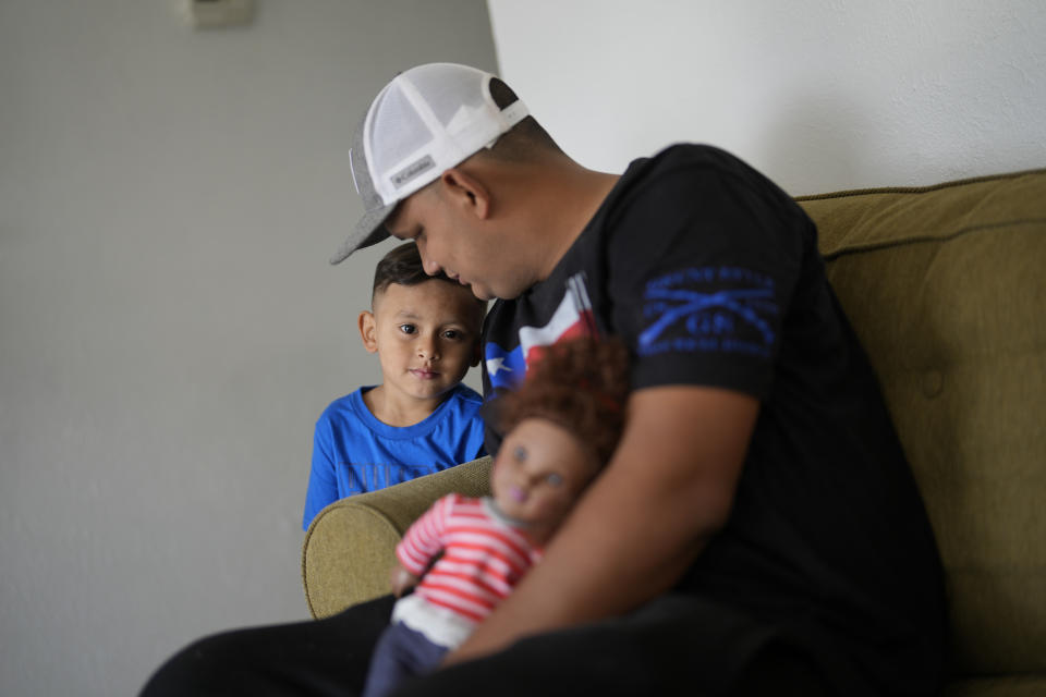 Alexis Llanos, 27, interacts with his three-year-old son who shares his name, inside the home the Llanos family moved into in October 2023, five years after fleeing Venezuela to Colombia to escape death threats and political persecution, in Lehigh Acres, Fla., Dec. 27, 2023. The family is among the first migrants allowed into the U.S. under the Biden administration's new "safe mobility offices," intended to streamline the U.S. refugee process so migrants don't give up and pay smugglers to make the journey north. (AP Photo/Rebecca Blackwell)