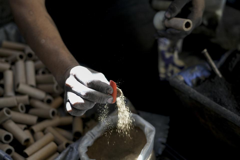 Rafael Martinez works with gunpowder to make fireworks at his family's workshop in preparation for the annual festival in honor of Saint John of God, the patron saint of the poor and sick whom fireworks producers view as a protective figure, in Tultepec, Mexico, Tuesday, March 5, 2024. (AP Photo/Marco Ugarte)