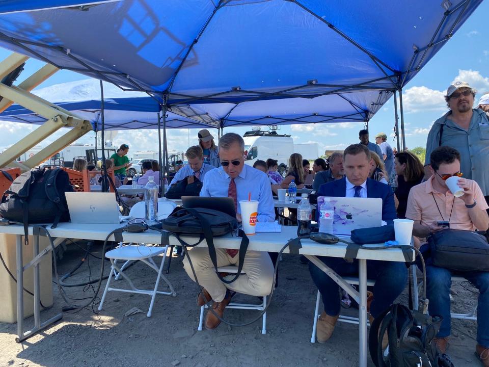 Members of the news media sit under a tent awaiting the arrival of President Joe Biden at Brayton Point in Somerset on July 22, 2022.