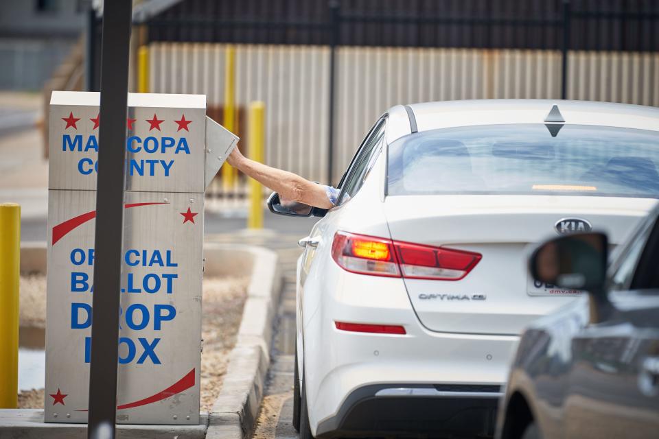 A voter drops off their ballot at the ballot drop box outside the Maricopa County Tabulation and Elections Center in Phoenix for Arizona's Aug. 2, 2022, primary election.