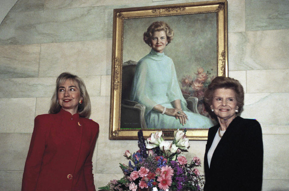 FILE - First lady Hillary Rodham Clinton poses with former first lady Betty Ford under Ford's White House portrait in Washington, March 2, 1993. (AP Photo/Ron Edmonds, File)