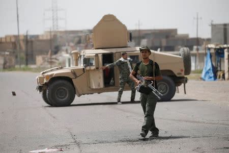 Members of the Shi'ite Badr Organisation walk with their weapons in Saqlawiya, north of Falluja, Iraq, June 5, 2016. REUTERS/Thaier Al-Sudani