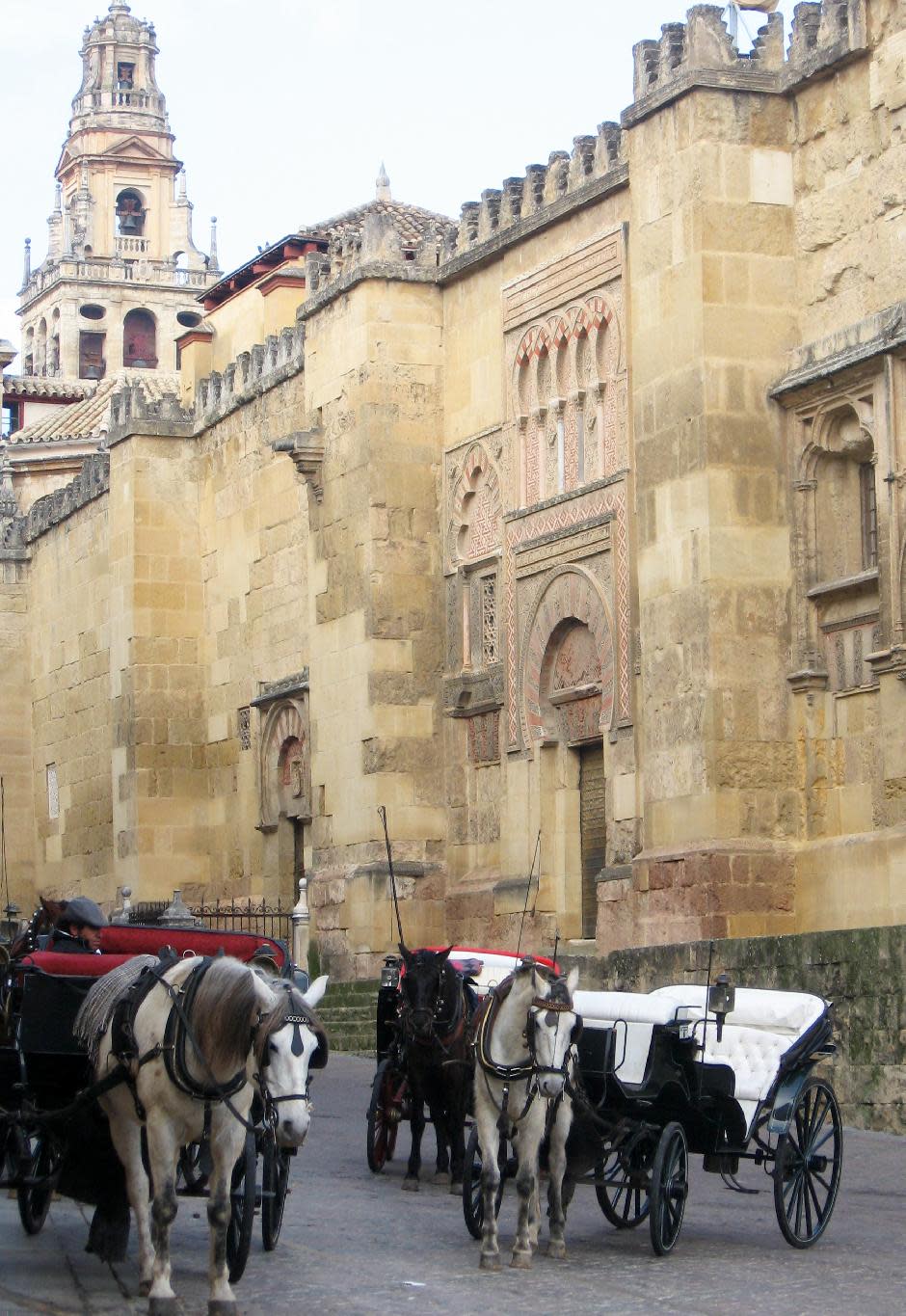 This Jan. 12, 2013 photo taken in Cordoba, in Andalusia, Spain, shows horse carriages waiting for tourists outside the Mezquita cathedral, which originated as a mosque when the city was the center of Islamic Europe a thousand years ago. Andalusia offers a fusion of Christian and Islamic cultures, found in architectural masterpieces and in everyday life. (AP Photo/Giovanna Dell’Orto)