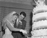 <p>Hollywood's girl next door looked radiant in the full-skirt lace bridal gown when she wed Eddie Fisher. The couple cut into their enormous tiered wedding cake at their reception in Liberty, New York. </p>