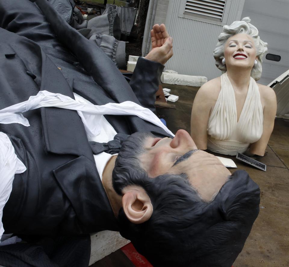 The torso of a 26-foot-tall, 34,000-pound statue named "Forever Marilyn" rests near a new oversized sculpture of former President Abraham Lincoln, entitled “Return Visit,” in Hamilton, N.J., Tuesday, April 8, 2014. The sculpture depicting Marilyn Monroe in her memorable billowing skirt pose from the "The Seven Year Itch" is part of an exhibit honoring its designer, Seward Johnson. “Icons Revisited” series of sculptures, depicts famous images from the arts and pop culture in a larger-than-life fashion. (AP Photo/Mel Evans)