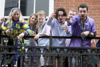 A group of revelers on a balcony toss beads to the crowd below on Bourbon Street on Mardi Gras day in New Orleans, Tuesday, Feb. 25, 2020. (AP Photo/Rusty Costanza)