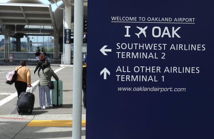 OAKLAND, CALIFORNIA - APRIL 12: Travelers walk towards Terminal 1 at Oakland International Airport on April 12, 2024 in Oakland, California. The Board of Commissioners for the Port of Oakland voted on Thursday to proceed with a plan to change the name of Oakland International Airport to the San Francisco Bay Oakland International Airport. San Francisco officials are objecting to the proposed name change and have threatened to file a lawsuit arguing it would violate the city's trademark on San Francisco International Airport and would potentially be confusing for people traveling to the area. (Photo by Justin Sullivan/Getty Images)