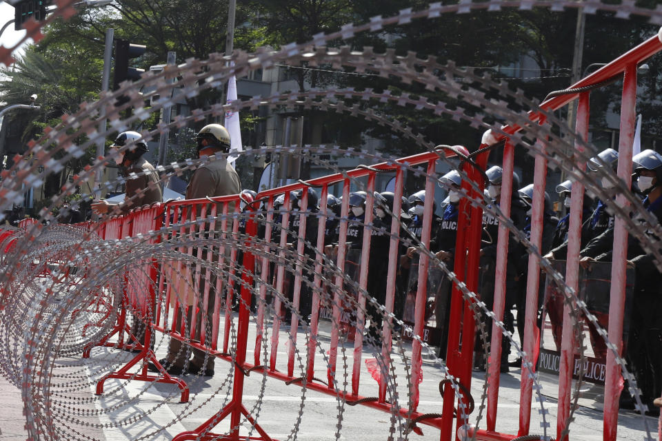 Police stand a guard behind razor wire during a demonstration near the Asia-Pacific Economic Cooperation (APEC) forum venue, Thursday, Nov. 17, 2022, in Bangkok, Thailand. A small but noisy group of protesters scuffled briefly with police demanding to deliver a letter to leaders attending the summit demanding various causes including removal of Prime Minister Prayuth Chan-ocha and abolition of Thailand's strict royal defamation laws. (AP Photo/Sarot Meksophawannakul)