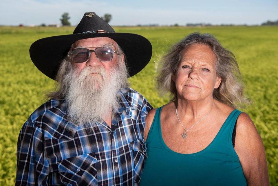 Frenchy Meissonnier, 72, left, and his wife Debi, 69, stand in front of a field of rice at Meissonnier Ranch, located along West Dickenson Ferry Road in Merced County, Calif., on Thursday, Aug. 11, 2022.