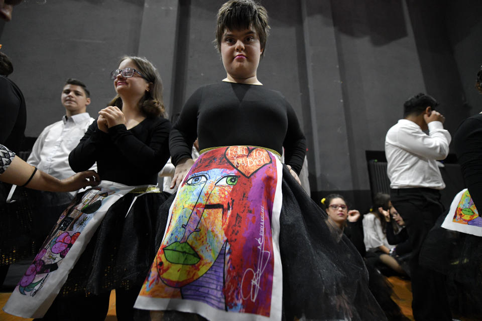 In this Nov. 3, 2019, photograph a child with Down syndrome prepare to show skirts displaying drawings inspired by children, during a fashion show dubbed "heART Couture" in Bucharest, Romania. Children with Down syndrome staged a fashion show and performed along a ballet ensemble, two milestone events for the inclusion of people with disabilities in Romania's social life, 30 years after the fall of communism following a violent uprising at the end of 1989.(AP Photo/Andreea Alexandru)