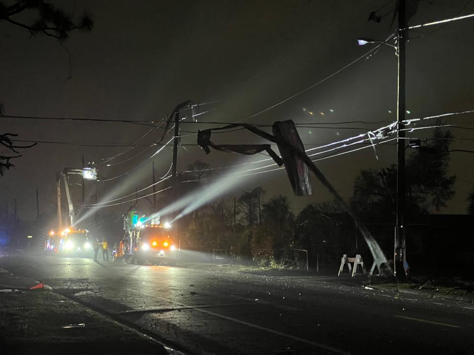 Workers survey the damage as metal is wrapped around power lines at 19th Street and Arthur Avenue in St. Andrews on Friday night.