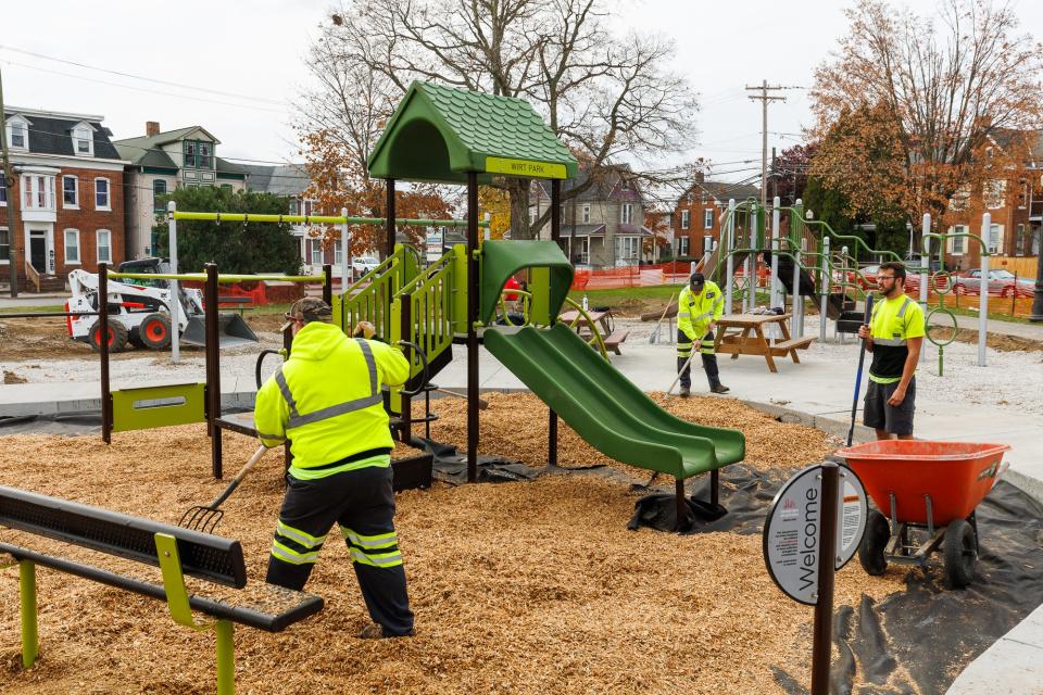 Volunteers and public works crews install a new playground at Wirt Park on Friday.