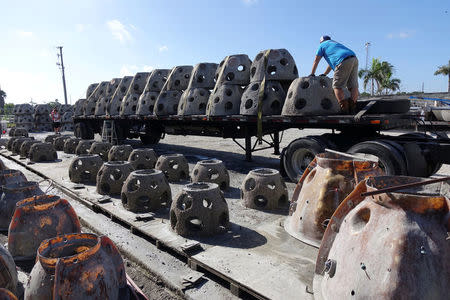 Workers unload some of the 66 Eternal Reef balls with plaques representing each of the submarines and crewmembers lost at sea since 1900, which will be deployed to the ocean floor for the undersea memorial during a ceremony this Memorial Day weekend, off the coast of Sarasota, Florida, U.S., May 23, 2018. Brian Dombrowski/EternalReefs.com/Handout via REUTERS