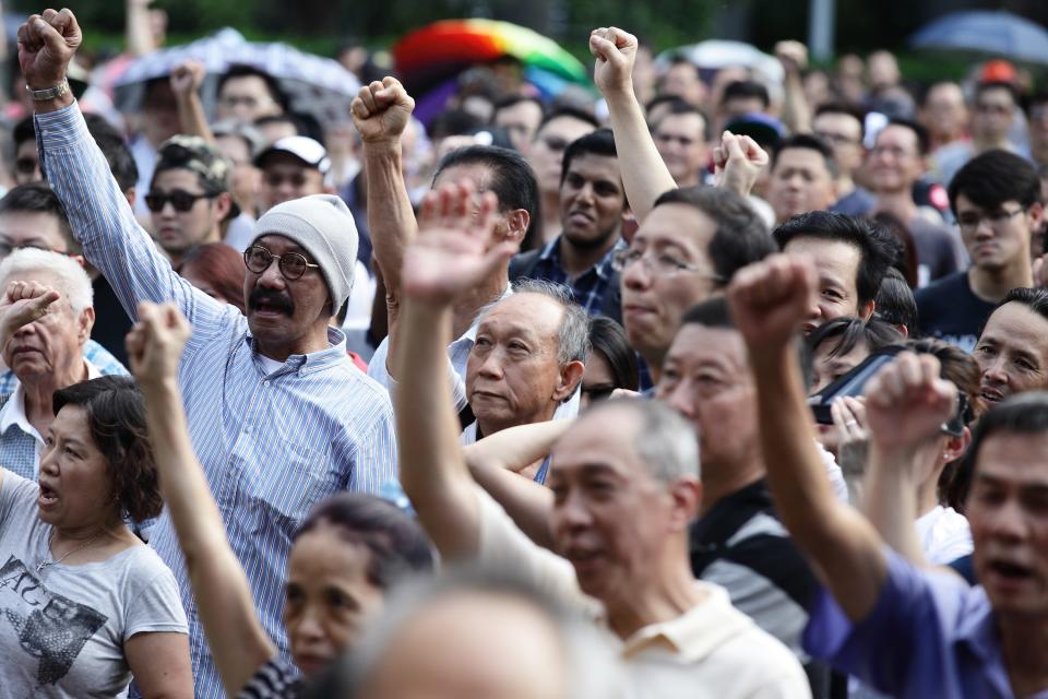 SINGAPORE - JUNE 07: People react to speaker speech during the &#39;Return Our CPF&#39; protest at the Speakers&#39; Corner at Hong Lim Park on June 7, 2014 in Singapore. The protest was staged to demand greater transparency and accountability from the government on how the CPF monies are being utilized. (Photo by Suhaimi Abdullah/Getty Images)