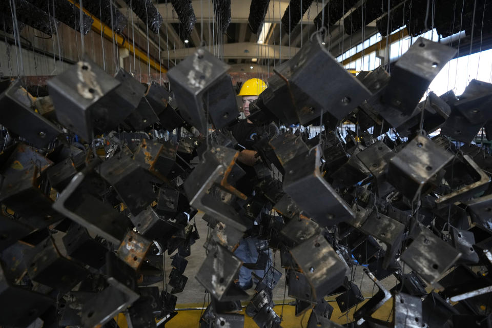 A man works in a galvanizing plant in Cambiano, northern Italy, Friday, Sept. 16, 2022. Zinc baths at Giambarini Group's galvanizing plants in northern Italy must remain super-heated around the clock, seven days a week, an energy-intensive process that has grown exponentially more costly as gas prices spike. The energy crisis facing Italian industry and households is a top voter concern going into Sunday's parliamentary elections as fears grow that astronomically high bills will shutter some businesses and force household rationing by winter. (AP Photo/Antonio Calanni)