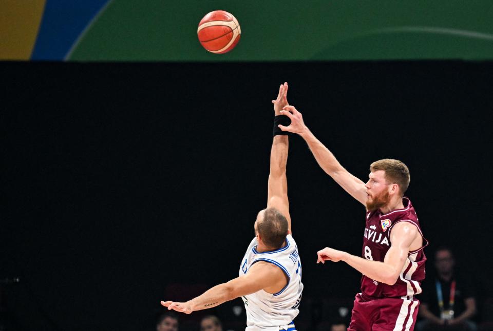 Latvia’s Davis Bertans (R) attempts a pass midair against Italy’s Stefano Tonut (L) during the FIBA Basketball World Cup classification semifinal match between Italy and Latvia in Manila on September 7, 2023. (Photo by SHERWIN VARDELEON / AFP) (Photo by SHERWIN VARDELEON/AFP via Getty Images)
