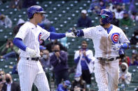 Chicago Cubs' Javier Baez, right, greets Matt Duffy outside the dugout after Baez scored on Duffy's sacrifice fly during the third inning of a baseball game against the Pittsburgh Pirates Fon riday, May 7, 2021, in Chicago. (AP Photo/Charles Rex Arbogast)