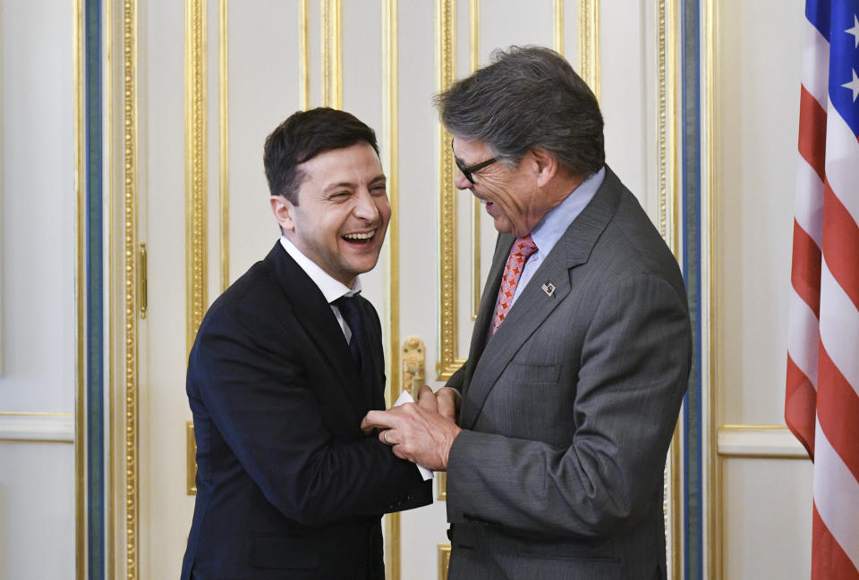 FILE - In this May 20, 2019, file photo, Ukrainian President Volodymyr Zelenskiy, left, and Energy Secretary Rick Perry share a joke during their meeting in Kiev, Ukraine. Michael Bleyzer and Alex Cranberg, two political supporters of Perry secured a potentially lucrative oil-and-gas exploration deal from the Ukrainian government soon after Perry proposed one of the men as an adviser to the country’s new president. (Mykola Lazarenko/Presidential Press Service Pool Photo via AP)