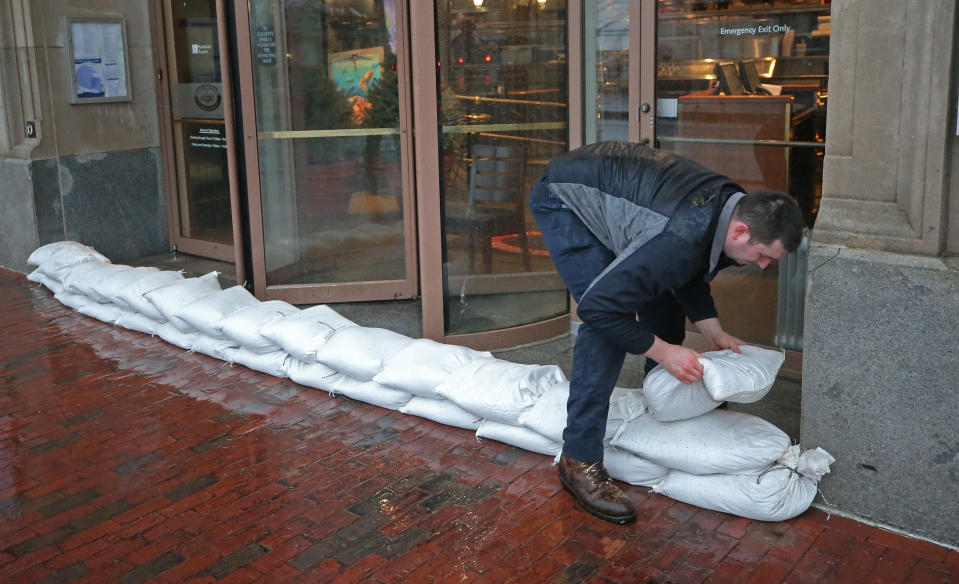 <p>Ryan Adams of JAL Properties management company stacks sandbags at the entrance of 255 State Street in Boston in anticipation of flooding from a nor’easter storm on March 2, 2018. (Photo: David L. Ryan/The Boston Globe via Getty Images) </p>