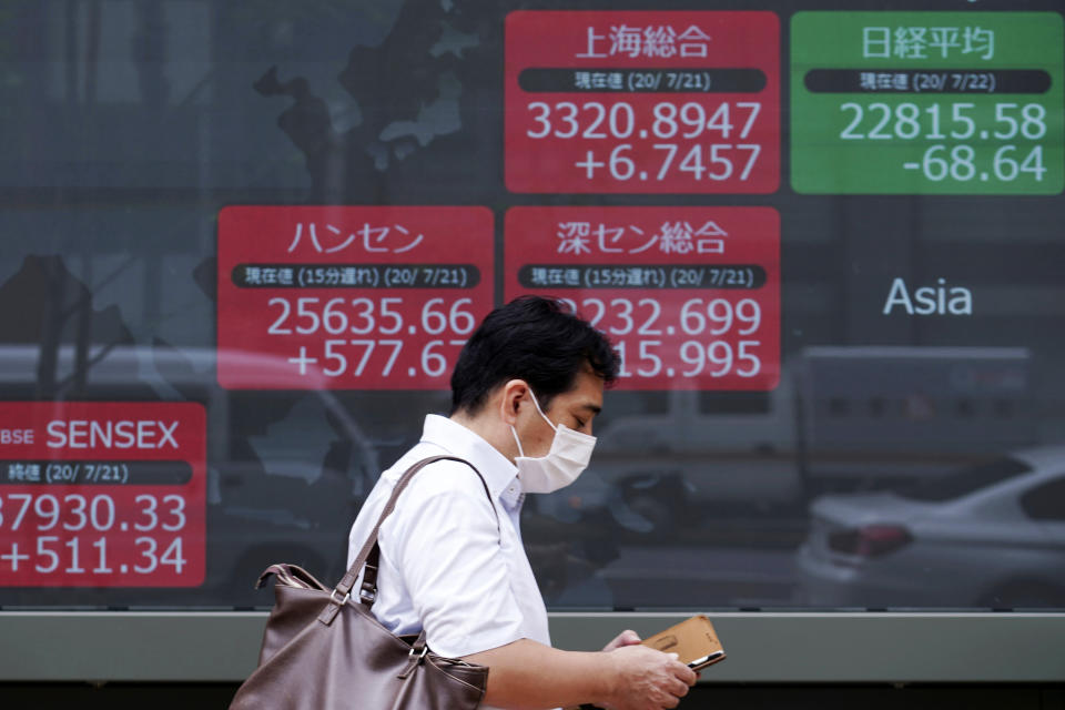 A man wearing a face mask walks past an electronic stock board showing Japan's Nikkei 225 and other Asian indexes at a securities firm in Tokyo Wednesday, July 22, 2020. Shares were mixed in Asia on Wednesday, with Australia’s benchmark down more than 1% on reports of a sharp rise in coronavirus cases in the Melbourne area. (AP Photo/Eugene Hoshiko)