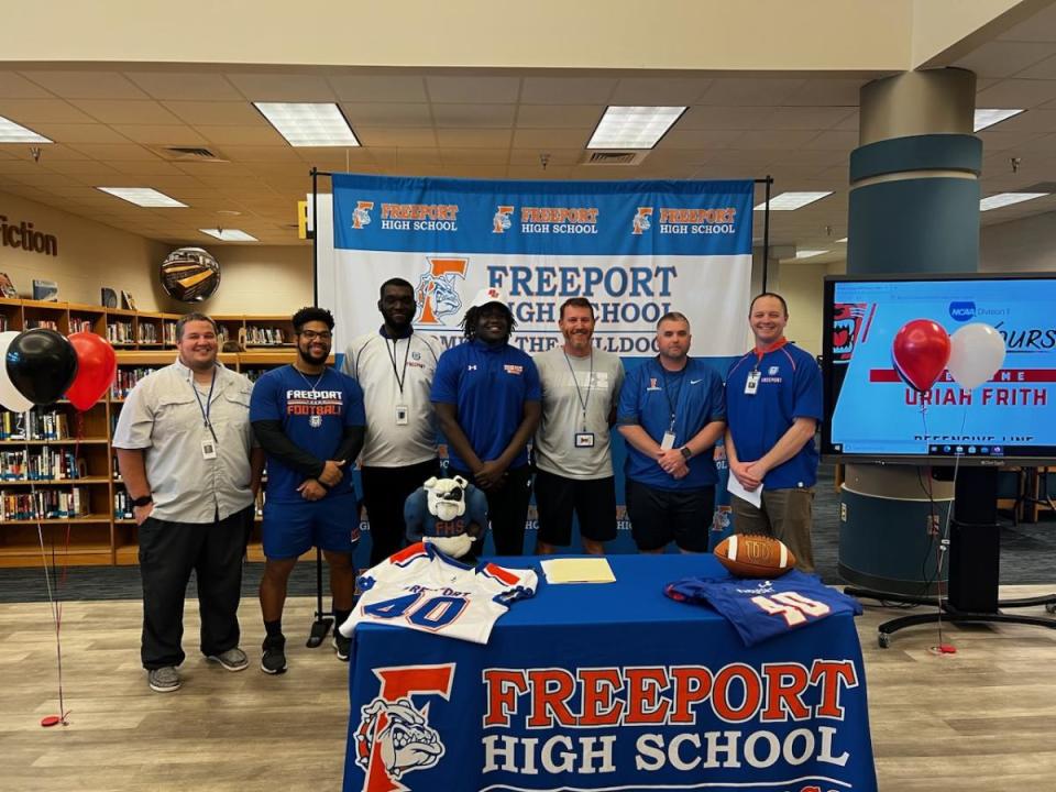 Freeport senior Uriah Frith poses with coaches during Wednesday's signing ceremony.