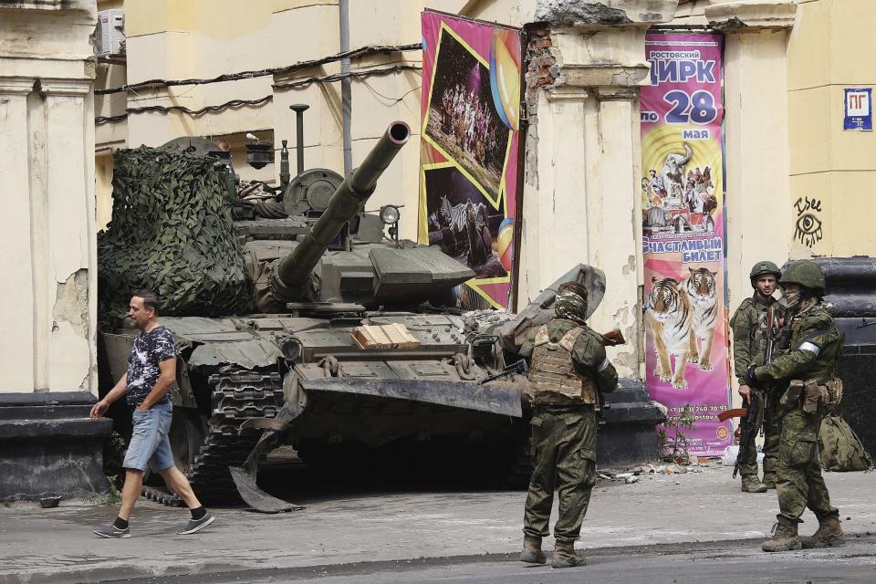 FILE - Members of the Wagner Group military company guard an area standing in front of a tank in a street in Rostov-on-Don, Russia, Saturday, June 24, 2023. Russia’s rebellious mercenary chief Yevgeny Prigozhin walked free from prosecution for his June 24 armed mutiny, and it’s still unclear if anyone will face any charges in the brief uprising against the military or for the deaths of the soldiers killed in it. (Vasily Deryugin, Kommersant Publishing House via AP, File)
