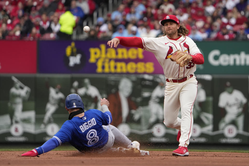 Toronto Blue Jays' Cavan Biggio (8) is out at second as St. Louis Cardinals second baseman Brendan Donovan (33) turns a double play to end the top of the second inning of a baseball game Saturday, April 1, 2023, in St. Louis. (AP Photo/Jeff Roberson)