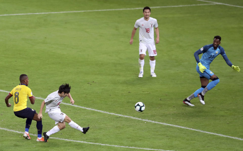 Japan's Shoya Nakajima, second left, strike the ball to score against Ecuador, as Ecuador's Carlos Gruezo, left, and goalkeeper Alexander Dominguez fail to stop him during a Copa America Group C soccer match at the Mineirao stadium in Belo Horizonte, Brazil, Monday, June 24, 2019. (AP Photo/Natacha Pisarenko)