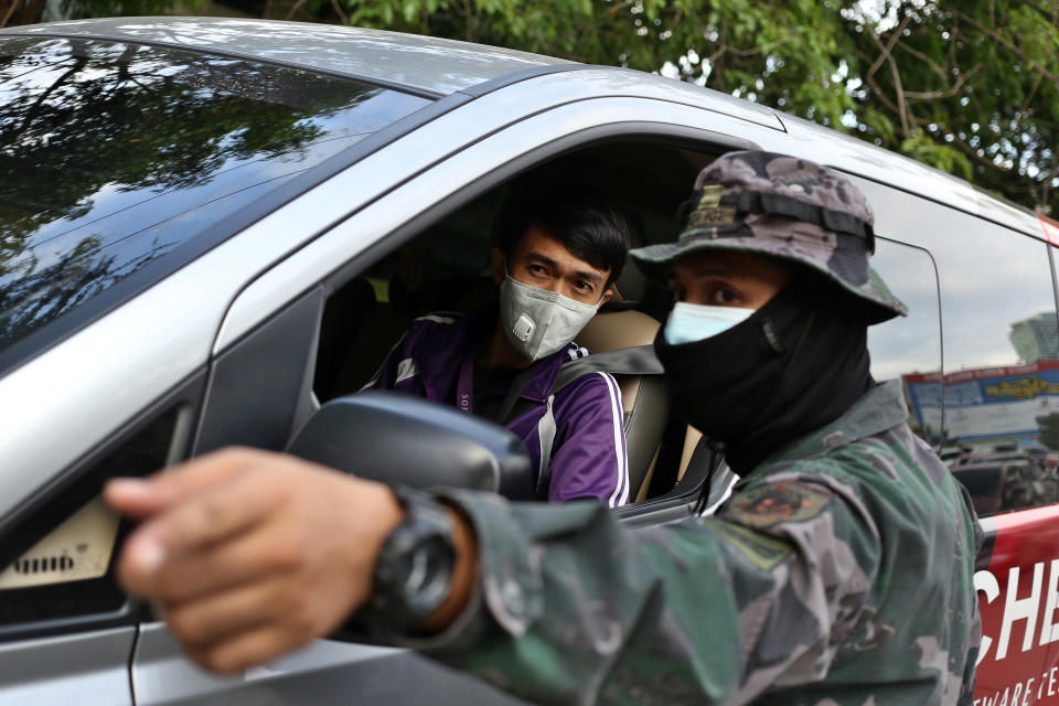 18 March 2020, Philippines, Manila: A soldier talks to a driver. President Duterte has placed all of Luzon - the largest island in the Philippines with 57 million people - under "tightened quarantine" and tightened the closure of Manila due to the COVID 19 pandemic. Photo: Alejandro Ernesto/dpa (Photo by Alejandro Ernesto/picture alliance via Getty Images)