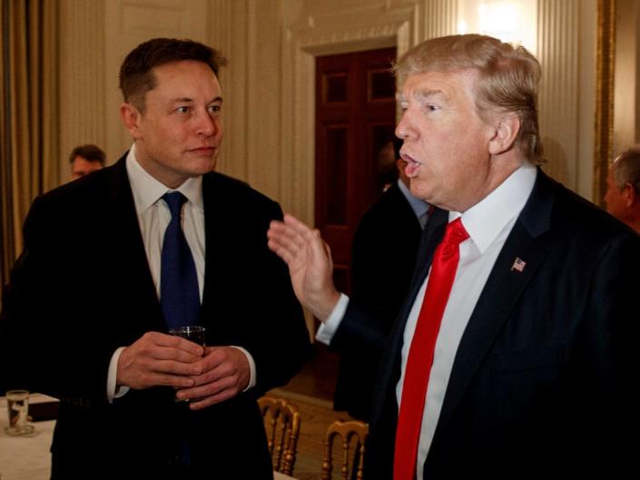 President Donald Trump talks with Tesla and SpaceX CEO Elon Musk, center, and White House chief strategist Steve Bannon during a meeting with business leaders in the State Dining Room of the White House in Washington, Friday, Feb. 3, 2017.
